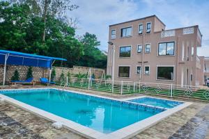 a house with a swimming pool in front of a house at Diani Tulivu in Diani Beach