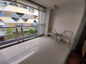 a balcony with two chairs and a large window at Nana Hiso Hotel in Bangkok