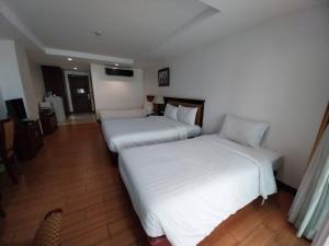 two beds in a hotel room with white sheets at Nana Hiso Hotel in Bangkok +70 photos