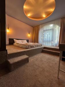 a bedroom with a large bed and a large window at Hotel Artimino in Timişoara