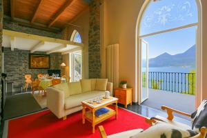 a living room with a couch and a large window at Villa Lucia Varenna in Varenna