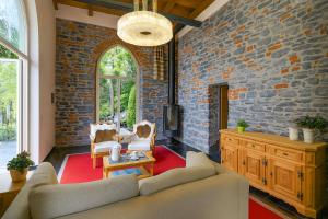 a living room with a couch and a brick wall at Villa Lucia Varenna in Varenna