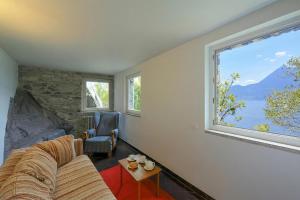 a living room with a couch and a large window at Villa Lucia Varenna in Varenna +14 photos