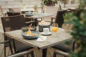 a wooden table with bowls of food and glasses of orange juice at Econnomy Adler in Golling an der Salzach