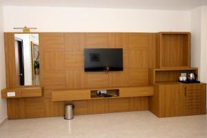 a room with a flat screen tv on a wooden wall at Hotel Grand Maspel in Dimapur