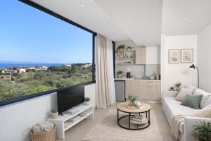 a living room with a large window and a couch at Suel Suites Afitos in Afitos