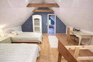 a attic room with two beds and a desk at The Cozy Cottage in Hirtshals