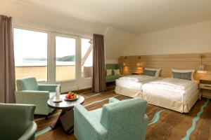 ラッツェブルクにあるHotel Der Seehofのベッド1台と椅子2脚が備わるホテルルームです。