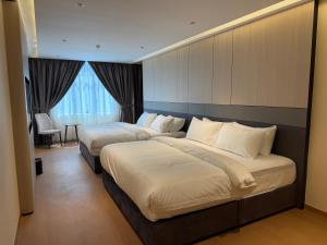 a hotel room with two beds and a table at ALL IN HOTEL in Kangar +60 photos