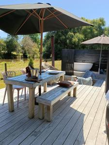 a picnic table and an umbrella on a deck at The Round Tent Raglan in Raglan