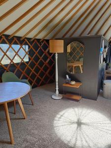 a room with a table and a lamp in a room at The Round Tent Raglan in Raglan