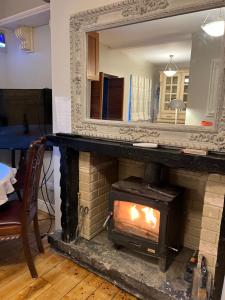 a fireplace with a mirror on top of it at Kilpedder cottage in Kilpedder
