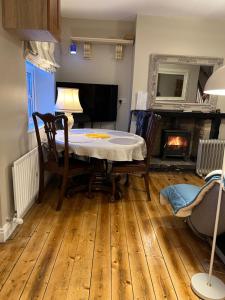 a dining room with a table and a fireplace at Kilpedder cottage in Kilpedder