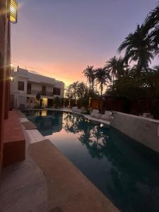 a swimming pool in front of a house with palm trees at Casa Mezcaleria formerly Boracay Beach Club in Boracay