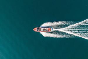 a boat is leaving a trail of white smoke at Villa Meraviglia - Private Villa with garden, pool and Breathtaking Lake Como Views in Colico