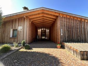 a large wooden building with a large entrance at Sirona Stay - Private Spa Retreat near Bolzano Dolomites - Romantic Stay with Sauna Whirlpool Garden Garage Free Bolzano Card in San Genesio Atesino