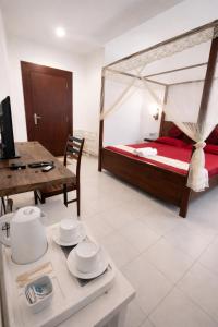 a bedroom with a bed and a table with dishes at W Hotel Mount Lavinia - Colombo in Colombo