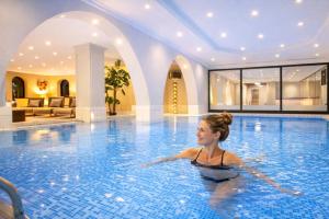 a woman swimming in a swimming pool at Das Kronberg Hotel - Adults Only - inkl Soft- und Heißgetränkeflat in Bodenmais