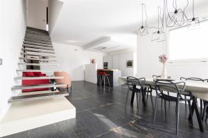 a dining room with a table and chairs and a staircase at IseoLakeRental - Villa Edwige in Provaglio d'Iseo