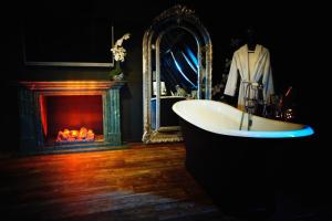 a bathroom with a bath tub and a fireplace at Domaine 10 in Schore