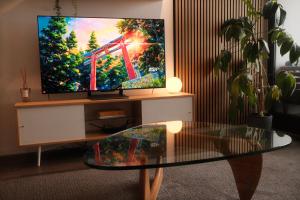 a living room with a tv and a glass table at Chapel Street Hideaway in Melbourne