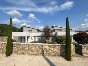 a house with a stone fence and trees at IseoLakeRental - Villa Edwige in Provaglio d'Iseo