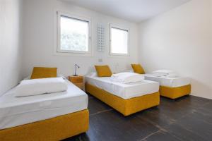 two beds in a room with two windows at IseoLakeRental - Villa Edwige in Provaglio d'Iseo