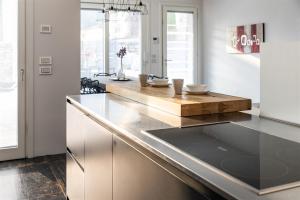 a kitchen with white cabinets and a wooden counter top at IseoLakeRental - Villa Edwige in Provaglio d'Iseo +38 photos