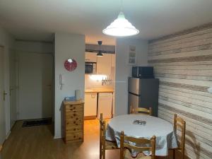 a small kitchen with a table and a refrigerator at Appartement 5 personnes centre de Luchon in Luchon