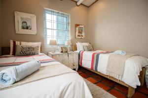 a bedroom with two beds and a window at Lekkerlag in Paternoster