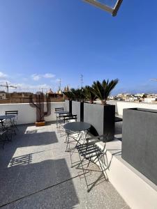 a patio with tables and chairs on a roof at Kappuccini Hill boutique hotel - By Tritoni Hotels in Il-Furjana