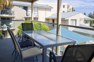 a glass table and chairs on a balcony at Scarborough Beach Front Resort - Shell Seven in Perth