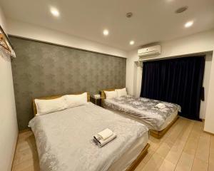 a bedroom with two beds and a window at 青葉邸 AOZORA 1002 Near Dotonbori 3LDK 2 Bath 2 WC Premium Tower Residence in Osaka