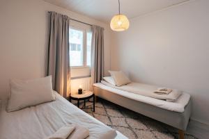 a bedroom with two beds and a window at Arctic Circle Holiday Homes in Rovaniemi