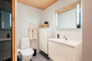 a bathroom with a white toilet and a sink at Arctic Circle Holiday Homes in Rovaniemi +30 photos