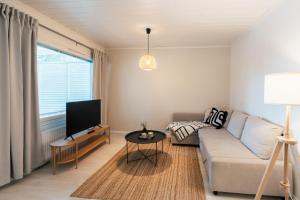 a living room with a couch and a tv at Arctic Circle Holiday Homes in Rovaniemi