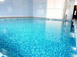a swimming pool with blue tiles on the floor at Glory Apart Polyana in Polyana