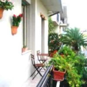 a balcony with chairs and potted plants on a building at Bed And Roses in Montesilvano
