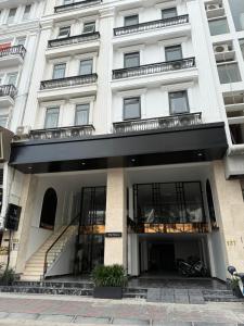 a white building with a staircase in front of it at The Nova Hotel & Apartment in Hai Phong