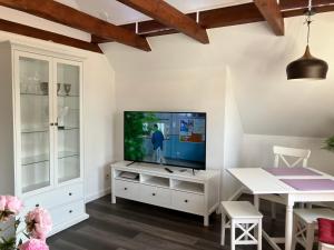 a living room with a television on a white cabinet at Ferienwohnung 5 Anna in Bergen auf Rügen