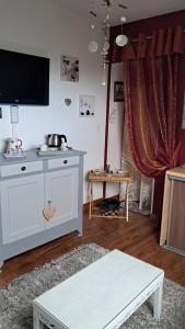a living room with a tv and a table at Aux Volets Bleus in Sibiril