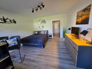 a bedroom with a bed and a tv in it at Ochsenkopf-apartment in Bischofsgrün
