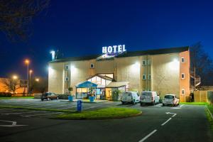 a hotel with cars parked in a parking lot at night at Kyriad Direct Macon Sud in Crêches-sur-Saône
