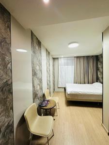 ein Zimmer mit einem Bett, einem Tisch und Stühlen in der Unterkunft Emoji Hotel in Ongon