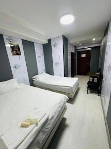 ein Zimmer mit zwei Betten und einem Stuhl in der Unterkunft Emoji Hotel in Ongon