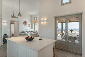 a kitchen with a bowl of fruit on a counter at Lolantonis - 3BR Sea View & Infinity Pool - Thymari in Aspro Chorio Paros +34 photos