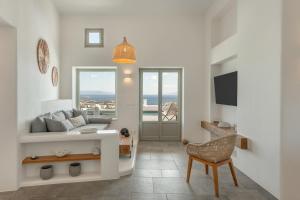 a living room with a couch and a chair at Lolantonis - 3BR Sea View & Infinity Pool - Thymari in Aspro Chorio Paros