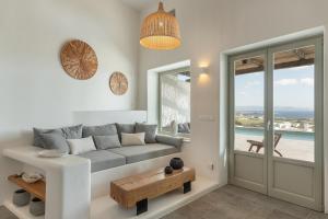 a living room with a couch and a table at Lolantonis - 3BR Sea View & Infinity Pool - Thymari in Aspro Chorio Paros