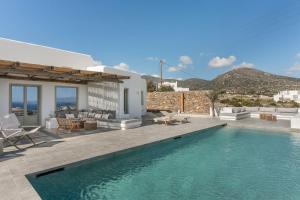 a villa with a swimming pool and a patio at Lolantonis - 3BR Sea View & Infinity Pool - Thymari in Aspro Chorio Paros
