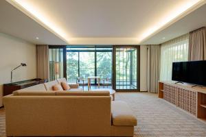 a living room with a couch and a television at Hyatt Regency Hakone Resort and Spa in Hakone